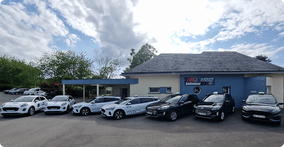 Plusieurs Véhicules sanitaires léger garés devant un batiment d'EMS Ambulances