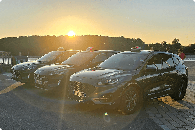 Trois taxi gérés avec un couché de soleil en fond